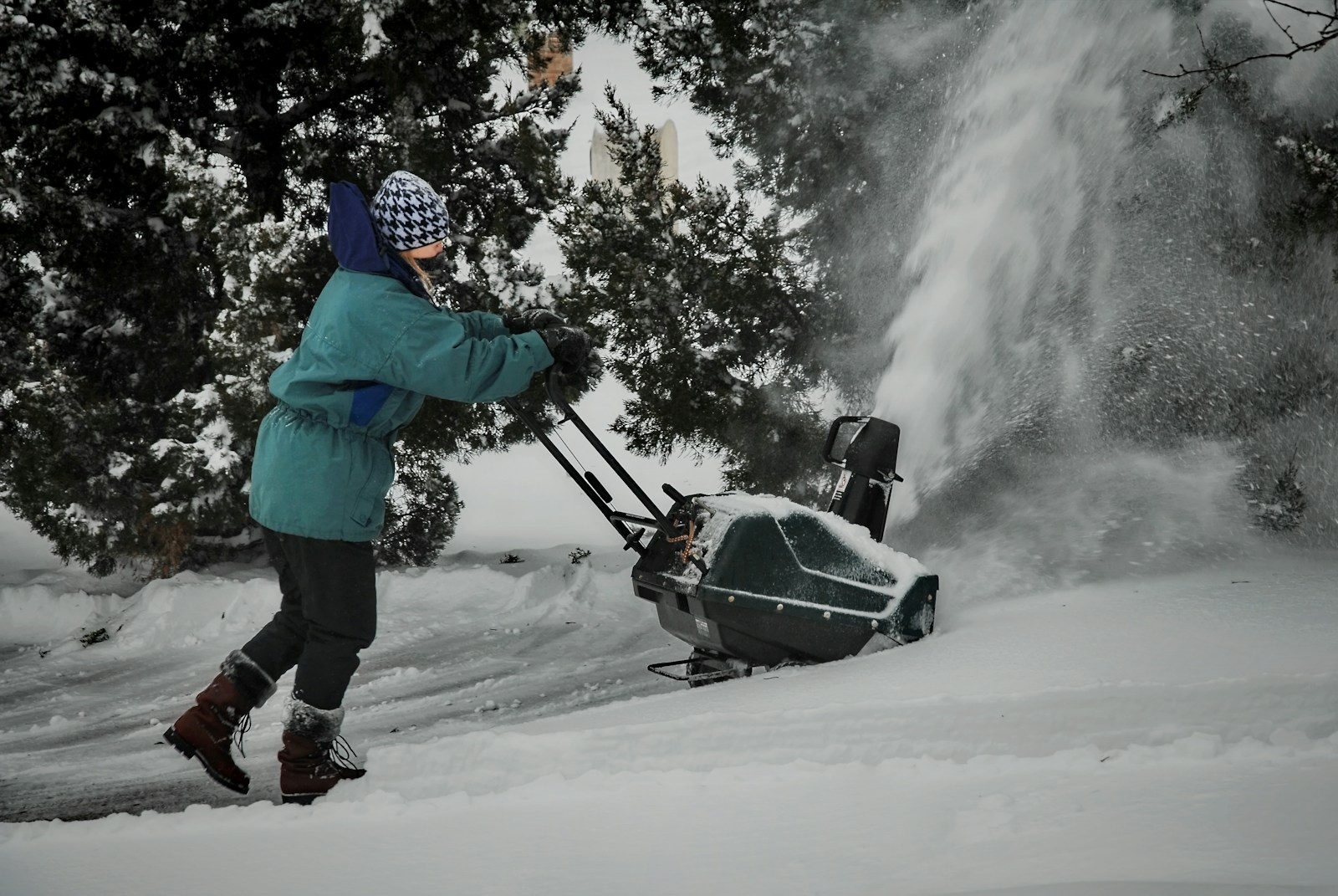 a person pushing a snow blower in the snow